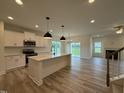 Open kitchen with stainless appliances, kitchen island and view of the living room at 21 Trescott St, Smithfield, NC 27577