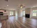 Open-concept living room features a fireplace, ceiling fan, and seamless access to the kitchen at 21 Trescott St, Smithfield, NC 27577