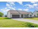 Single story home boasts attached two car garage, covered area, manicured lawn and appealing neutral color palette at 210 Maxwell Farm Ln, Selma, NC 27576