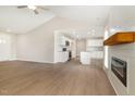 Stylish living area with vaulted ceiling, hardwood floors, ceiling fan, and a sleek fireplace with a wooden mantle at 210 Maxwell Farm Ln, Selma, NC 27576