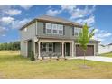 Beautiful home featuring a side entry garage, manicured lawn, and complementary shrubs and trees at 212 Tuscany Cir, Princeton, NC 27569
