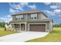 Charming two-story home with a two-car garage, inviting front porch, and well-maintained landscaping at 212 Tuscany Cir, Princeton, NC 27569