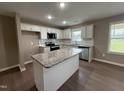Bright kitchen features granite counters, a center island, and stainless steel appliances at 212 Tuscany Cir, Princeton, NC 27569