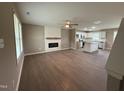 Spacious living room featuring wood floors, a fireplace, and open layout to the kitchen at 212 Tuscany Cir, Princeton, NC 27569