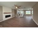 Open-concept living room with modern fireplace and wood flooring, connecting to the kitchen at 212 Tuscany Cir, Princeton, NC 27569