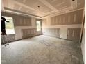 Spacious bedroom with tray ceiling, two windows for natural light, and primed walls ready for finishing at 221 Tee Dr, Selma, NC 27576