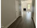 Hallway with wood floors and neutral walls leading to living room with fireplace at 221 Tee Dr, Selma, NC 27576