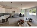 Open kitchen featuring a center island, stainless steel appliances, and white cabinets at 221 Tee Dr, Selma, NC 27576