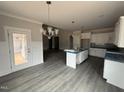 Open kitchen with granite countertops, white cabinets, and stainless steel appliances at 221 Tee Dr, Selma, NC 27576