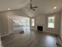 Open-concept living room featuring a fireplace, ceiling fan, and seamless flow to the modern kitchen at 221 Tee Dr, Selma, NC 27576