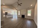Open concept living room and kitchen with hardwood floors, fireplace and large windows at 221 Tee Dr, Selma, NC 27576