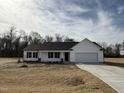 Charming single-story home featuring a classic white facade and a two-car garage at 225 Phil Jack Rd, Dunn, NC 28334
