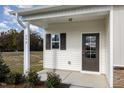 Charming front porch featuring a detailed entry door, window, and manicured landscaping at 246 Trescott St, Smithfield, NC 27577