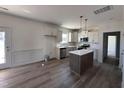 Bright kitchen with stainless appliances, white cabinets, island, and tile backsplash at 253 Trescott St, Smithfield, NC 27577