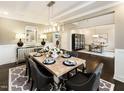 Elegant dining room with a modern chandelier, a table set for six, and hardwood floors at 276 E Fountainhead Ln # 166, Garner, NC 27529