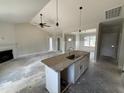 View of a kitchen island with a sink, pendant lights and an open living area at 28 Bailey-Boykin Rd, Selma, NC 27576