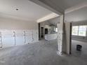 Unfinished living room with wainscoting details and an open floor plan to the kitchen with natural light at 28 Bailey-Boykin Rd, Selma, NC 27576
