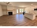 Spacious living room with fireplace, modern ceiling fan, wood floors, and access to the kitchen and backyard at 282 Trescott St, Smithfield, NC 27577