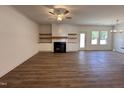 Bright and airy living room with hardwood floors, a ceiling fan, a fireplace with custom shelving, and plenty of natural light at 282 Trescott St, Smithfield, NC 27577