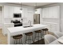 Modern kitchen featuring white cabinetry, stainless steel appliances, a kitchen island with seating at 815 Central Park Dr, Knightdale, NC 27604