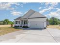 Attractive one-story home boasts a wide driveway, white exterior, and a convenient two-car garage at 30 Tee Dr, Selma, NC 27576