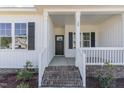 Welcoming front porch with brick steps, white railings, and a stylish front door, offering curb appeal at 30 Tee Dr, Selma, NC 27576