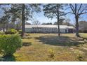 View of backyard showing some of the surrounding yard and trees on a sunny day at 309 14Th St, Butner, NC 27509