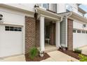 Welcoming townhome entrance with brick columns, covered porch, and access to the garage at 309 Millennium Dr, Pittsboro, NC 27312