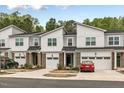Modern townhome complex featuring brick and siding exteriors, garages, and manicured lawns at 309 Millennium Dr, Pittsboro, NC 27312