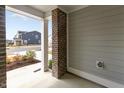 Cozy porch view showcasing brick columns, siding, and a glimpse of the neighborhood street at 309 Millennium Dr, Pittsboro, NC 27312