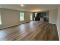 Open-concept living room and kitchen with hardwood floors and modern lighting at 33 W Emily Gardens Dr, Selma, NC 27576