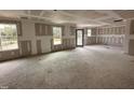 A large living room features drywall-covered walls with three windows and an exterior door providing ample natural light at 33 W Emily Gardens Dr, Selma, NC 27576