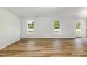 Spacious living room with light walls, wood-look floors, and natural light from windows at 33 W Emily Gardens Dr, Selma, NC 27576
