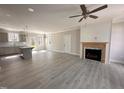 Open living room with wood-look floors, fireplace, ceiling fan and access to the modern kitchen at 39 N Rowsham Pl, Smithfield, NC 27577