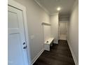 Functional entryway featuring coat hooks, a bench, and dark wood flooring at 40 Bailey-Boykin Rd, Selma, NC 27576