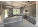 Spacious kitchen with gray cabinets, large windows, and an island awaiting finishing at 40 Bailey-Boykin Rd, Selma, NC 27576