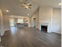 Spacious living room featuring wood floors, a vaulted ceiling, and fireplace, flowing into a modern kitchen at 40 Bailey-Boykin Rd, Selma, NC 27576