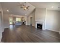 Bright open-concept living room featuring fireplace, ceiling fan, and hardwood floors at 40 Bailey-Boykin Rd, Selma, NC 27576