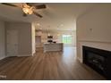 Open-concept living space with fireplace, ceiling fan, and views into kitchen at 40 Tuskeegee Dr, Smithfield, NC 27577