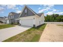 Exterior view of a two-car garage with vinyl siding and a paved driveway and landscaping at 41 W Emily Gardens Dr, Selma, NC 27576