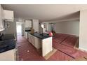 Open-concept kitchen featuring an island, white cabinets, modern fixtures, and an adjacent living area at 41 W Emily Gardens Dr, Selma, NC 27576