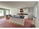 Bright kitchen with white cabinets, a dark countertop island, modern appliances, and natural light at 41 W Emily Gardens Dr, Selma, NC 27576