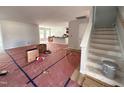 Spacious, unfinished living room area featuring light-grey walls, an open staircase, and access to the kitchen at 41 W Emily Gardens Dr, Selma, NC 27576