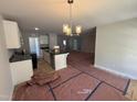Open floor plan showcasing the kitchen with its island and chandelier above the future dining area at 41 W Emily Gardens Dr, Selma, NC 27576