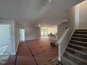 Spacious living room, showcasing stairs to a second floor and view into kitchen with natural light at 41 W Emily Gardens Dr, Selma, NC 27576