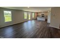 A spacious kitchen and living room area with white cabinets and an island at 43 Chloe Ct, Selma, NC 27576