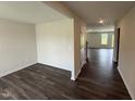 Living room featuring wood flooring, base trim, neutral colored walls and an open concept to the dining area at 43 Chloe Ct, Selma, NC 27576