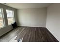 Bright bedroom featuring hardwood floors, white trim, and large windows at 43 Chloe Ct, Selma, NC 27577