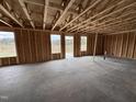 Interior shot shows open-concept framing and unfinished concrete floor in new construction home at 43 Chloe Ct, Selma, NC 27577