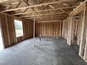 Interior shot shows open-concept framing and unfinished concrete floor in new construction home at 43 Chloe Ct, Selma, NC 27577